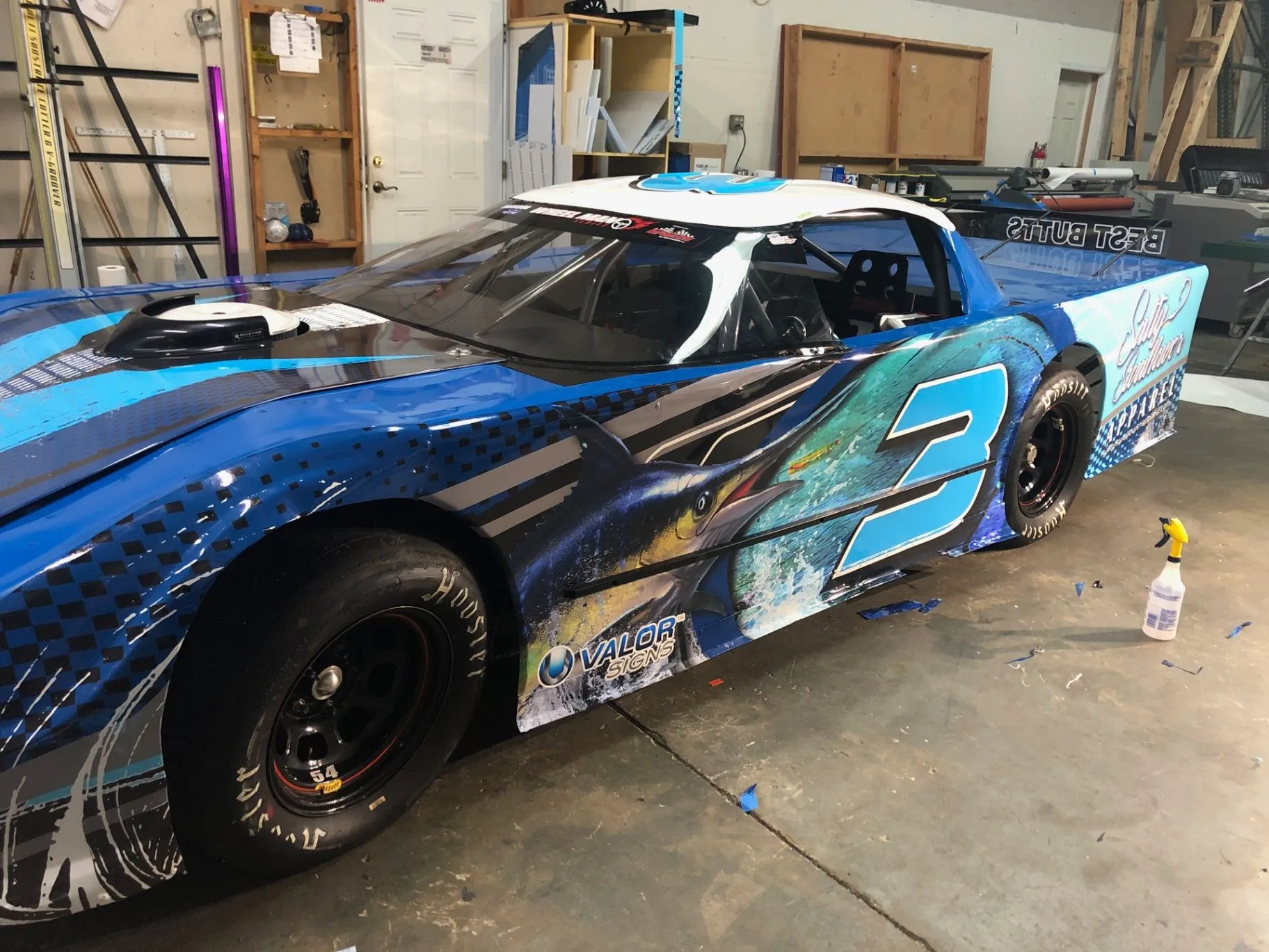Blue custom race car wrap with marlin artwork and racing number graphics